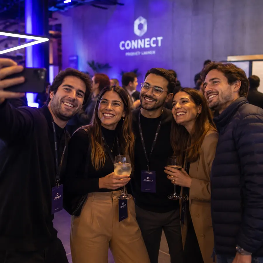 Convidados tirando selfie em um evento corporativo.